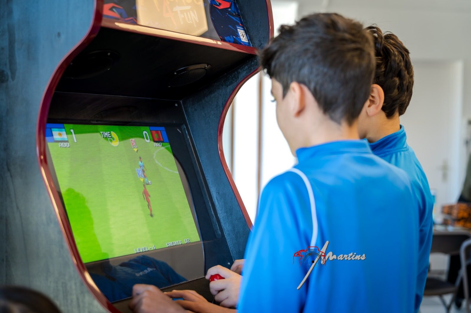 Deux enfants jouent sur une borne d'arcade Arcade 4 Fun pendant un événement.